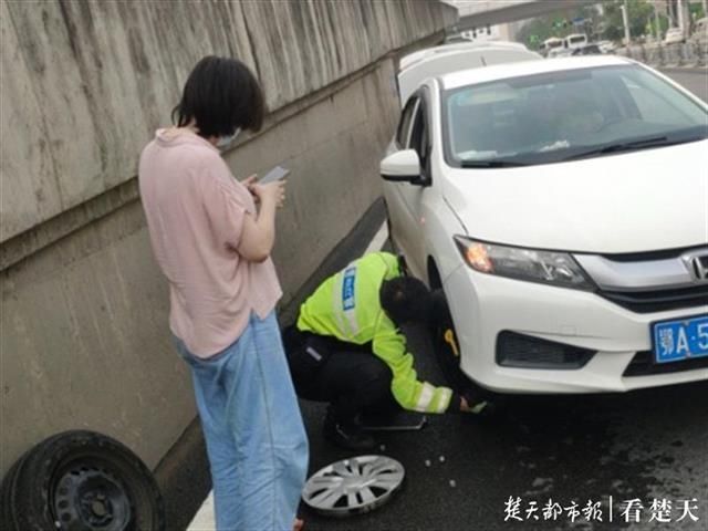  爆胎|女司机驾车半路爆胎，路过的交警帮她换好