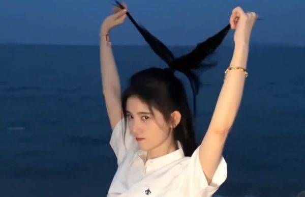  拍照|鞠婧祎穿白衬衫在海边散步，拍照时突然拽起自己的头发，网友顿时愣了