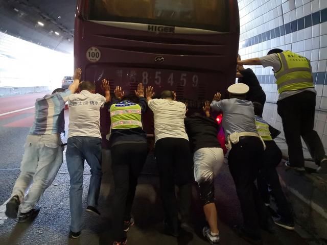  耗尽|大客车燃油耗尽抛锚，交警与乘客合力将车推出隧道