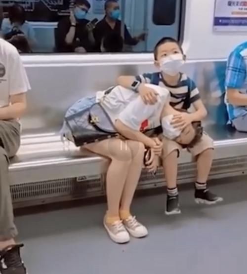 小男孩|男孩地铁上守护熟睡妈妈，让妈妈枕在腿上安心入睡，网友：真暖心
