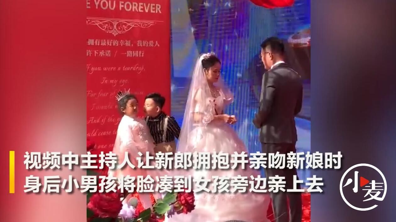 小女孩|婚礼现场司仪让新郎亲吻新娘，身后男花童献吻小女孩抢镜